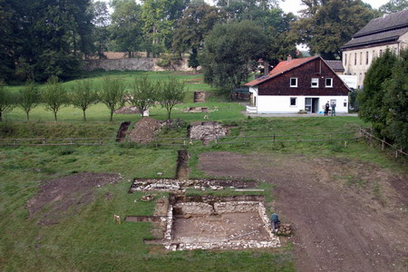 Abb. 5: Die Aufnahme zeigt den Bereich des ehemaligen Konventgartens von Osten aus gesehen während der Ausgrabungen im Jahr 2004. Gut zu erkennen ist die quadratische Brunnenanlage im Vordergrund. Darüber der quer verlaufende Mühlkanal und weiter oben die Fundamentierung der breiten Freitreppe auf der Mittelachse des Gartens. Foto: M. Preißler
